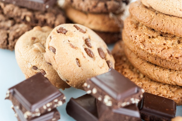 Homemade corded wholegrain cookies with oatmeal, linen and sesame seeds and traditional cookies with chocolate chips and pieces broken chocolate bars with seeds and nuts. Healthy vegan food concept.