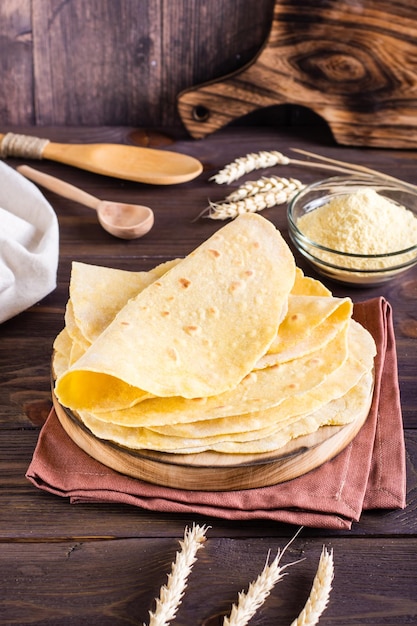 Le tortillas messicane di mais fatte in casa si avvolgono su una tavola sul  tavolo vista verticale