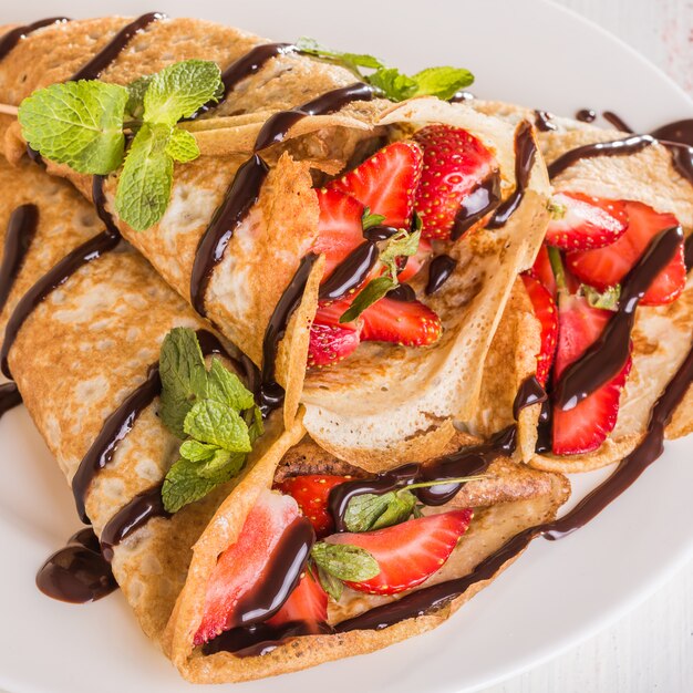 Homemade Crepes with strawberries and chocolate syrup