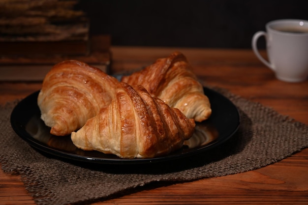 Homemade croissants with and coffee cup on wooden table Breakfast bread bakery products cafe concept