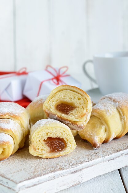 Homemade croissants with fruit jam, decorated with powdered sugar