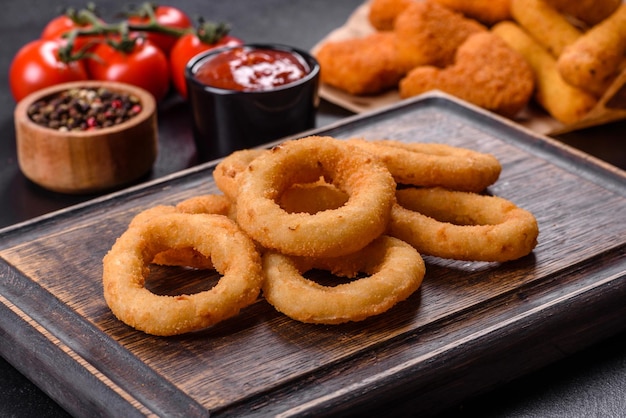 Homemade crunchy fried onion rings with tomato sauce