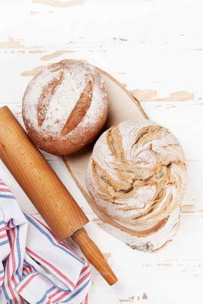 Homemade crusty bread on white wooden table. Top view with space for your text