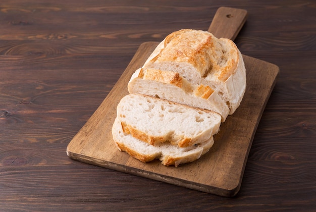 A homemade crusty loaf of bread on dark background