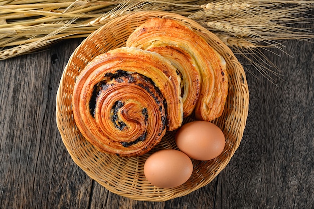 Homemade danish pastry in basket. top down. wood table.