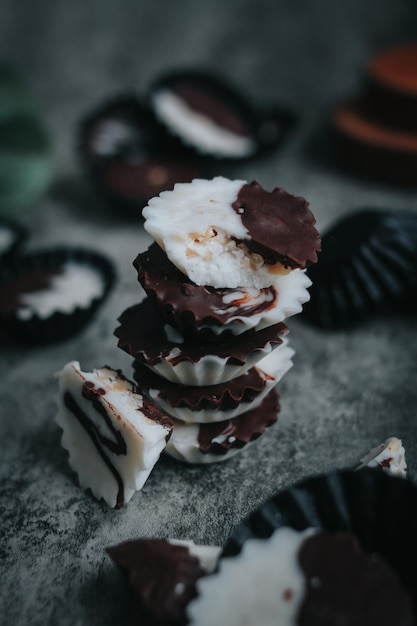 Homemade dark chocolate and white cup on a black pack chocolate cup with rustic grey background