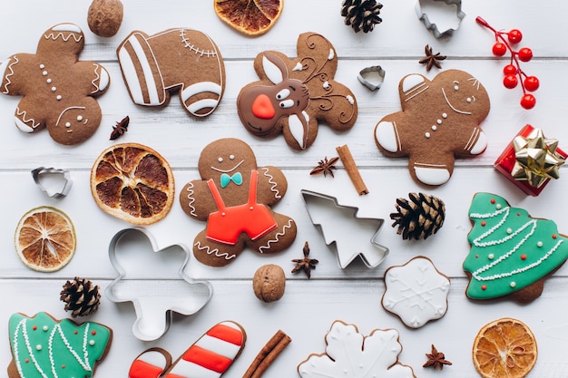 Homemade delicious Christmas gingerbread cookies on the white wooden background.