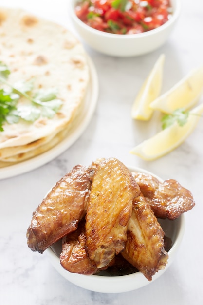 Homemade delicious food of tortillas, salsa and fried wings.