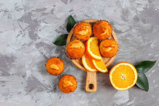 Homemade delicious orange muffins with fresh oranges.