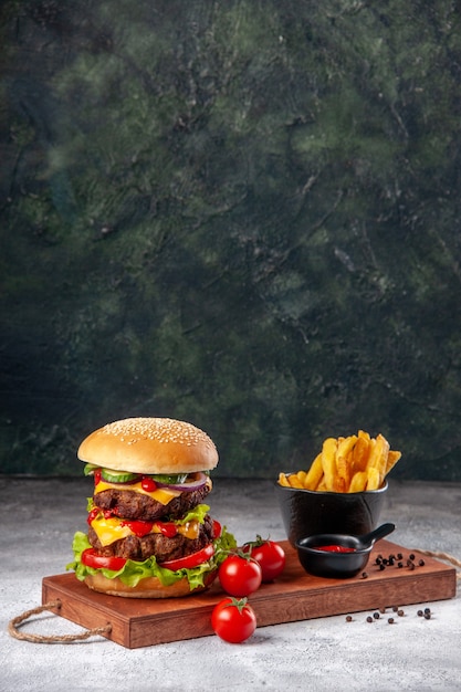 Homemade delicious sandwich tomatoes ketchup pepper fries on wooden board on blurred surface