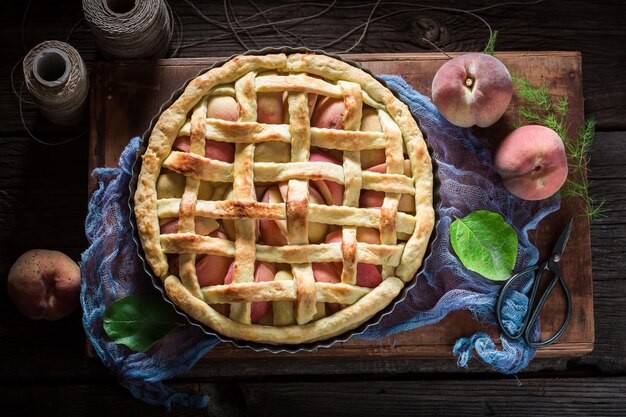 Homemade and delicious tart with peaches on blue cloth