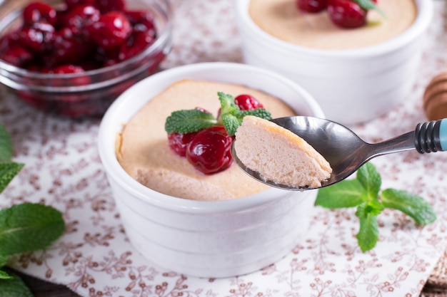 Panna cotta dolce fatta in casa con ciliegia e menta in forma di ceramica bianca