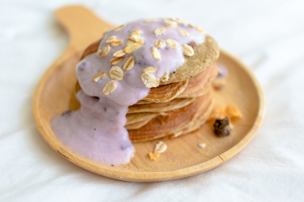 Homemade diet pancake with mixed fruits yogurt on white bed in the morning.