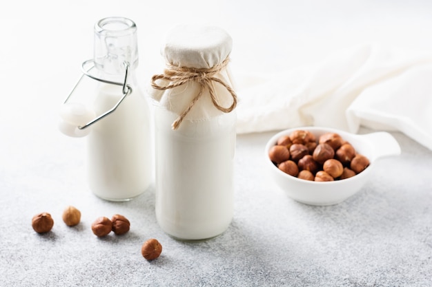 Latte e noci della nocciola di verdure casalinghi di dieta su un gray. concetto sano di dieta. copia spazio.