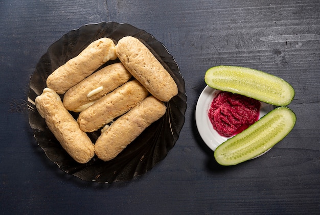 Homemade dietary chicken sausages, cucumbers and beet root sause on a wooden table