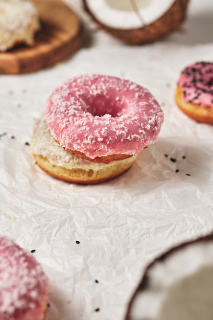 Homemade donuts with coconut and black sesame seeds in multicolored glaze