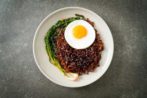 Homemade dried Korean spicy black sauce instant noodles with fried egg and kimchi