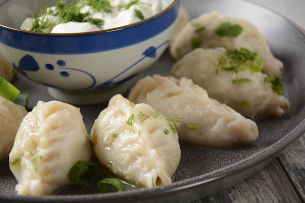 Homemade dumplings Dagestan cuisine Kurze Dumplings kurze with meet filling and adjika hot sauce on a plate