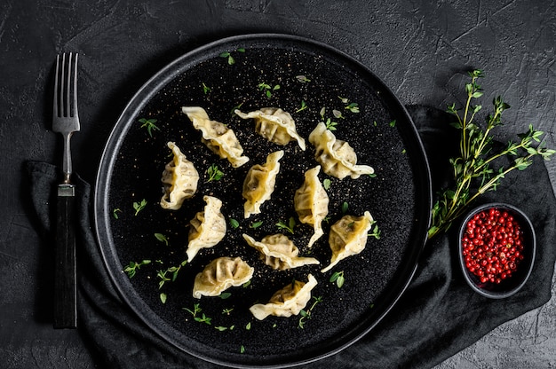 Homemade dumplings stuffed with meat. Black background. Top view