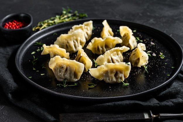 Homemade dumplings stuffed with meat. Black background. Top view