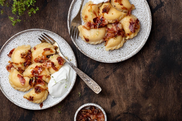 Homemade dumplings with potatoes, fried bacon and onions