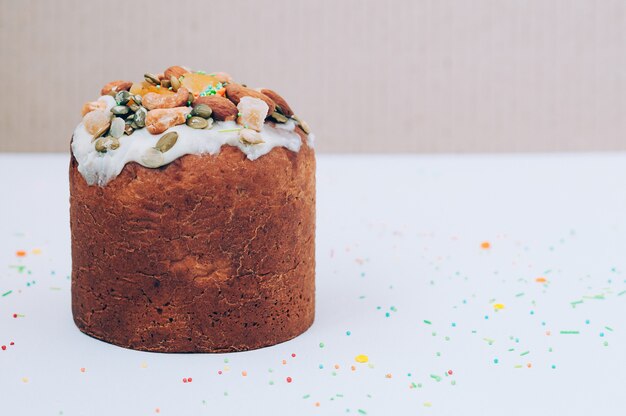 Homemade Easter cake decorated with icing, nuts, candied fruit