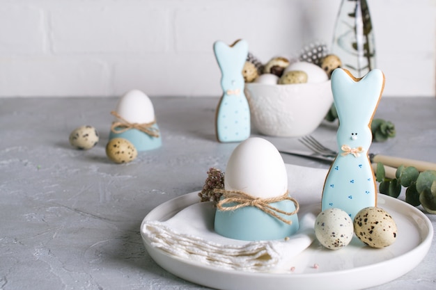 Homemade easter cookies in the shape of  a  funny  bunny, quail eggs  and chicken egg. Easter  celebration table setting. Holiday decorations.