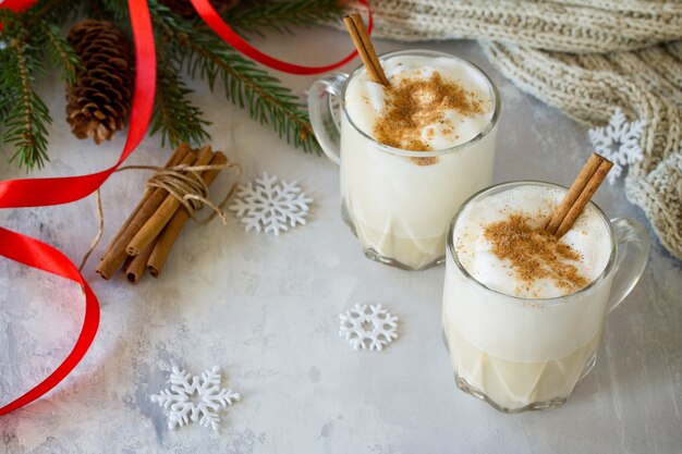 Homemade Eggnog Christmas milkshake met kaneel geserveerd in twee kopjes