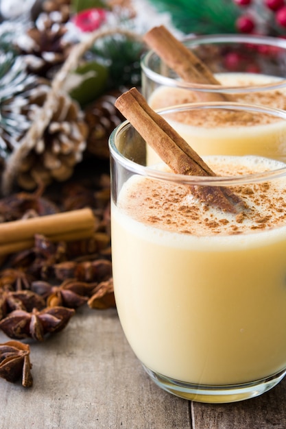 Homemade eggnog with cinnamon on wooden table Typical Christmas dessert