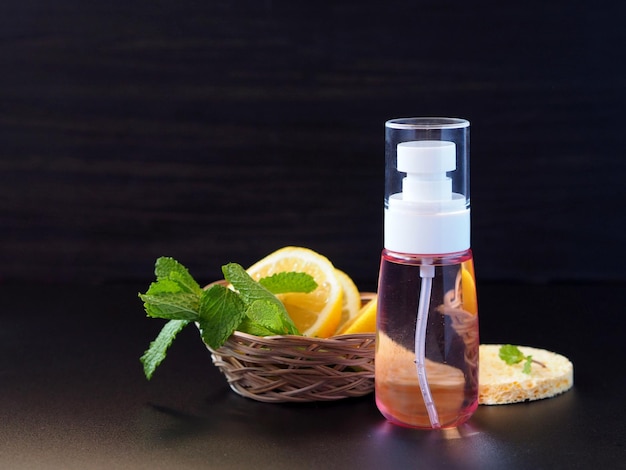 Homemade face lotion in a bottle with spray isolated on black