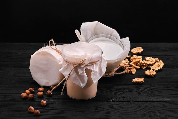 Homemade fermented baked milk in transparent bowl on an old dark background. Rustic. Milk products. Background image, copy space.