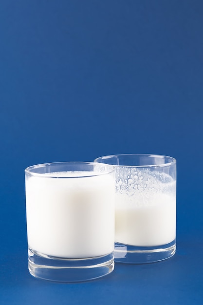 Homemade fermented beverage kefir in two glass on a trendy blue background, concept of natural fermented food and intestinal health