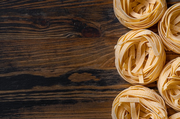 Homemade fettuccine pasta folded in the shape of a nest Home cooking with ingredients for homemade traditional Italian fettuccine pasta