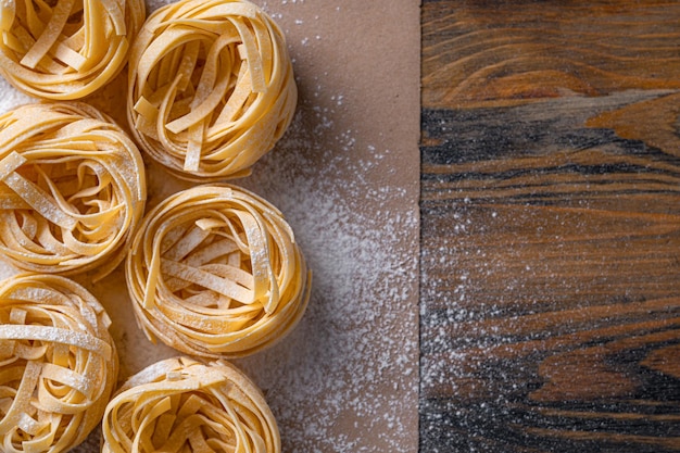 Fettuccine fatte in casa piegate a forma di nido cucina casalinga con ingredienti per fettuccine fatte in casa della tradizione italiana