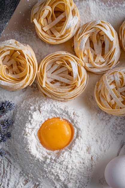 Homemade fettuccine pasta folded in the shape of a nest Home cooking with ingredients for homemade traditional Italian fettuccine pasta