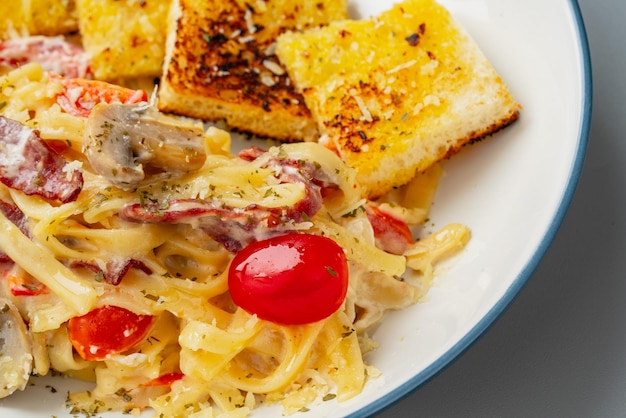 Homemade fettuccine pasta with white cream sauce and garlic bread