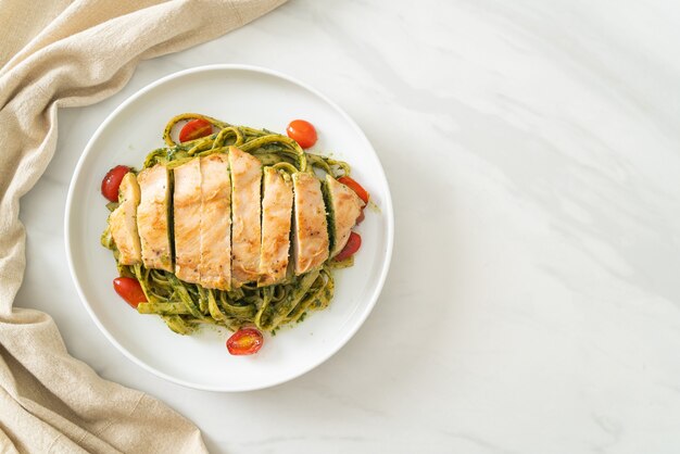 homemade fettuccine spaghetti pasta in pesto sauce with grilled chicken