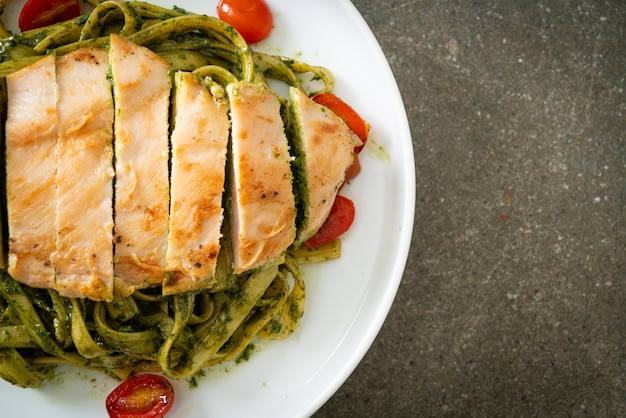 homemade fettuccine spaghetti pasta in pesto sauce with grilled chicken