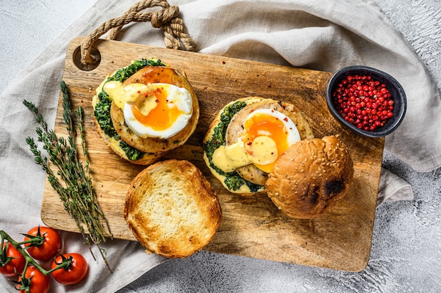 Homemade fish Burger with cod fillet, egg and spinach on a brioche bun. Gray background. Top view