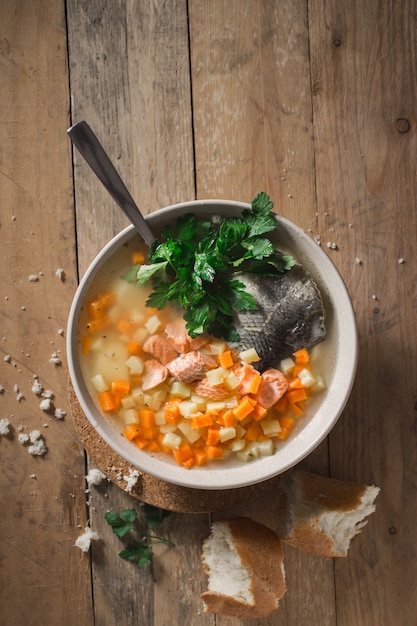 Foto zuppa di pesce fatta in casa nel piatto su un tavolo di legno