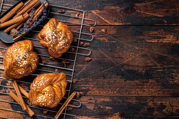 직접 만든 신선한 구운 계피 만두 또는 롤 스웨덴 Kanelbullar 어두운 나무 배경 상위 뷰 복사 공간