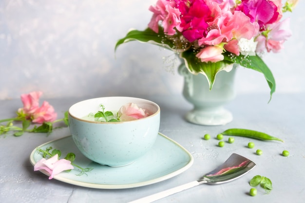 완두콩 콩나물과 꽃으로 만든 신선한 녹색 완두콩 크림 스프