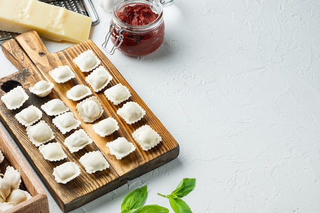 Homemade fresh Italian ravioli pasta set  on wooden board, on white background , 