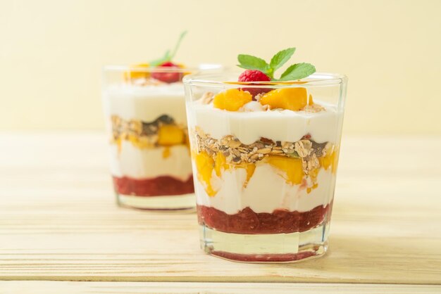 homemade fresh mango and fresh raspberry with yogurt and granola - healthy food style