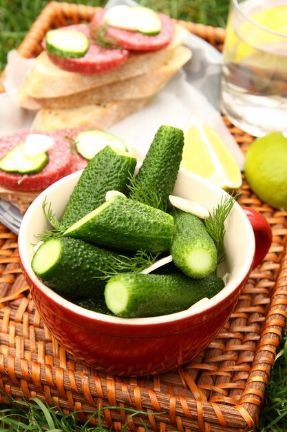 Homemade fresh salted cucumbers in the bowl and sandwiches with smoked sausage