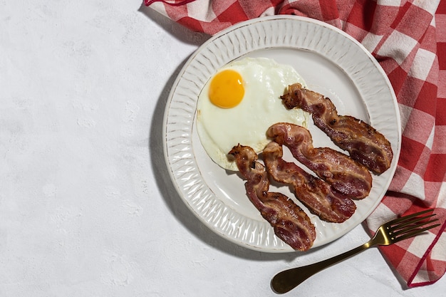 Homemade Fried egg with bacon. Traditional British breakfast in sunlight