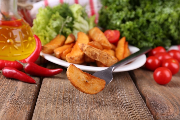 Foto patate fritte fatte in casa sul piatto su fondo di legno