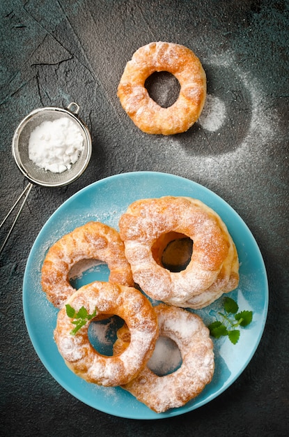 Ciambelle di ricotta alla vaniglia fritte fatte in casa su uno sfondo di cemento scuro