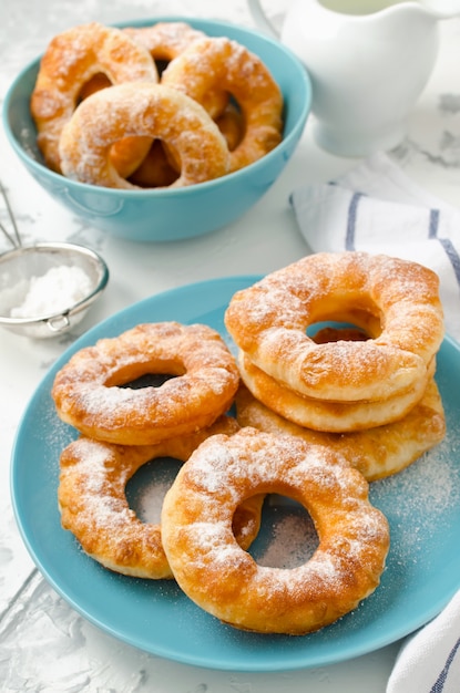 Homemade fried vanilla cottage cheese donuts on a white concrete background