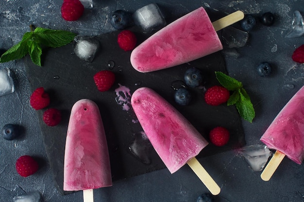 Homemade frozen fruit popsicles with fresh natural raspberry and blueberry